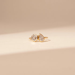 Front view of a 14KT Yellow Gold diamond ring with adjacent hexagonal and pear-shaped centre diamonds.