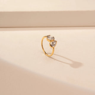 Angled view of a 14KT Yellow Gold diamond ring with adjacent hexagonal and pear-shaped centre diamonds.