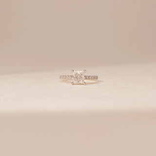 Front view of a 14KT Yellow Gold diamond ring with a rectangular centre diamond in a four-prong setting and diamond-set shoulders.