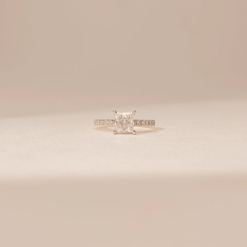Front view of a 14KT Yellow Gold diamond ring with a rectangular centre diamond in a four-prong setting and diamond-set shoulders.