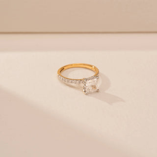 Side view of a 14KT Yellow Gold diamond ring with a rectangular centre diamond in a four-prong setting and diamond-set shoulders.