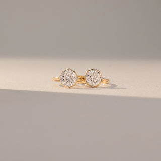 Front view of Dual Round Diamond Ring in 14KT Yellow Gold, featuring two round lab grown diamonds in prong settings on an open band. Set on a beige backdrop, the design highlights symmetry and modern elegance.
