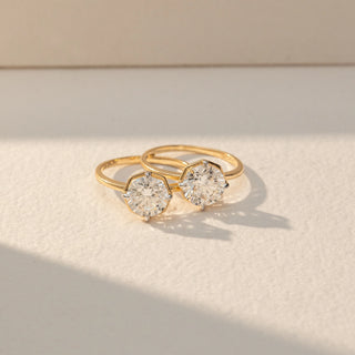 Top view of Dual Round Diamond Ring in 14KT Yellow Gold, featuring two round lab grown diamonds in prong settings on an open band. Set on a beige backdrop, the design highlights symmetry and refined elegance.
