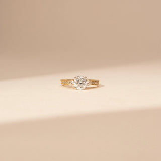 Front view of a 14KT Yellow Gold diamond ring with a round centre diamond and diamond-set shoulders.