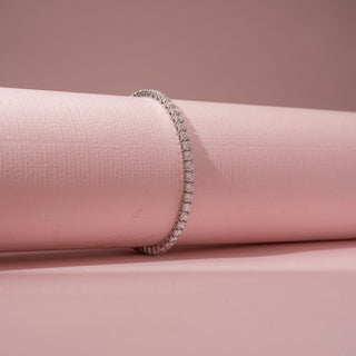 Angled view of a 14KT White Gold diamond bracelet featuring a continuous row of rectangular diamond accents.