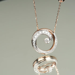 A mirror reflection of the front view of a Pendant Necklace crafted in 14 KT female rose gold of size 20 secured through a spring lock. The total weight of the necklace is 6.22 grams and the total weight of the diamonds is 0.602. The female necklace features a graceful swirl design with two central diamonds, adding a touch of brilliance. The pendant is displayed on a mirror background, enhancing the elegance and sparkle of the lab-grown diamonds through reflections