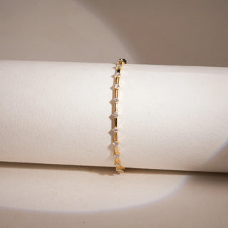 This is a classic yellow gold bangle size 2.5 features multiple lab grown diamonds of EF color and VVS clarity, totaling a 1.32 carats. The largest single stone measure 0.051, all balanced beutifully across totaling weight of 9.707 carats.The bangle is signature piece for those who appreciate elelvated minimalism.The front view of the bangle against the badge background on a bangle holder highlights the elegance and minimilist approach of the bangle.
