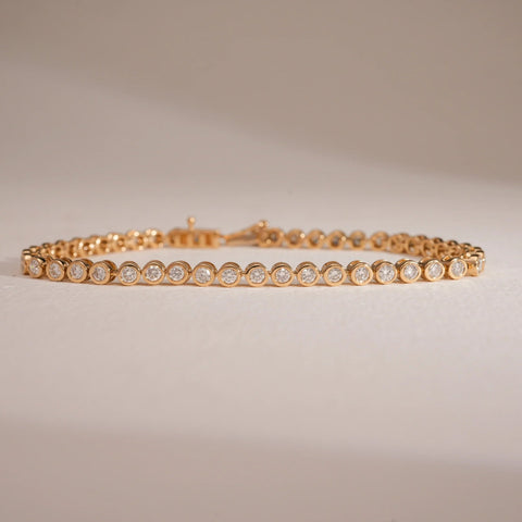 A luxurious 18 KT yellow gold bracelet, gross weight 10.428g and 6.7 inches in length, featuring multiple rows of brilliant round EF VVS diamonds totaling 2.200 carats, forming a wide, dazzling band. The bracelet is displayed on a subtly textured dark surface, with soft lighting emphasizing its opulent design and exceptional continuous sparkle.