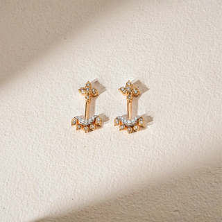 Front view of Reia's Temple Crest Diamond Studded Koppu displayed on a beige background. The design features floral diamond motifs and a vertical bar in 18KT yellow gold, adorned with EF VVS round lab grown diamonds totaling 0.280 carats. The intricate detailing and symmetrical silhouette evoke traditional temple-inspired craftsmanship.