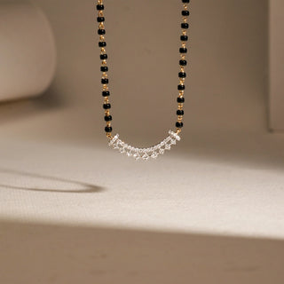 On a white background, the front view of a delicate 18 KT yellow gold MNG necklace is presented, radiating timeless charm. With a gross weight of 4.796 grams and a net gold weight of 3.354 grams, it is adorned with 0.310 carats of diamonds, the largest stone measuring 0.027 ct. The fine detailing and balanced proportions lend elegance, while a secure clasp ensures a comfortable fit for both special occasions and everyday wear.