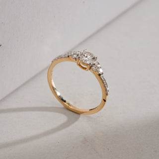 The Radiant Celeste Solitaire Diamond Ring in 14KT Yellow Gold with a round-cut solitaire and pavé EF VVS diamonds on the band, totalling 0.61 carats, symbolising timeless elegance.