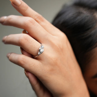 On a model's hand A close-up top of a female ring of size 12, on a model, showcasing a contemporary twist design with intertwining diamond of a trinity. Crafted in 14 KT white gold, the total diamond carat weight is 0.65 carats with a solitaire of 0.51 carats and the weight of the product is 2.15 grams, creating a dazzling and intricate look