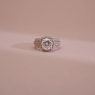 Close-up of 18KT White Gold Bold Cushion Diamond Statement Ring featuring a brilliant round centre diamond with pavé halo and wide EF VVS diamond-studded band for striking luxury appeal.