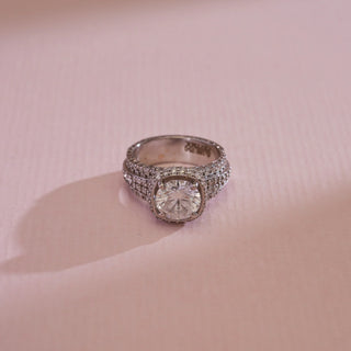 Top view of 18KT White Gold Bold Cushion Diamond Statement Ring with round solitaire, pavé halo and triple-row EF VVS diamond band, radiating bold elegance.