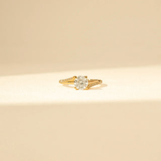 Close up view of Round Solitaire Diamond Ring in 14KT Yellow Gold, featuring a round brilliant-cut diamond and pavé-set curved bands.