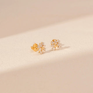 Angled view of Sunburst Diamond Stud Earrings in 14KT Yellow Gold, featuring a floral design with baguette and round diamonds.