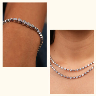 Diamond tennis bracelet and matching layered necklace by Réia, shown worn on the wrist and neckline, highlighting evenly set round stones in close-up against warm skin tones under soft lighting.