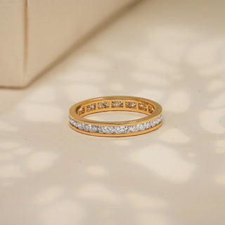 Channel-set band ring featuring a row of round-cut diamonds along the center, framed by smooth gold edges for a clean and timeless design.
