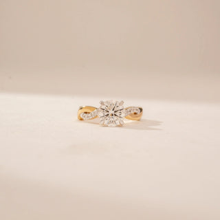 Front view of a 14KT Yellow Gold diamond ring, featuring a round centre diamond and twisted diamond-set band.