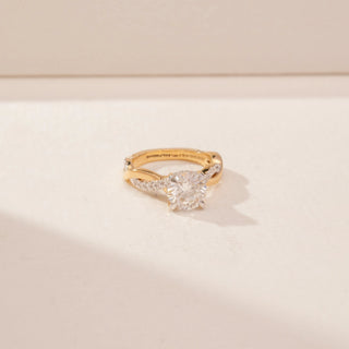 Side view of a 14KT Yellow Gold diamond ring, featuring a round centre diamond and twisted diamond-set band.