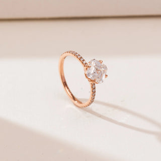 Angled view of Kite Set Asscher Diamond Ring in rose gold, featuring a kite-oriented Asscher-cut lab-grown diamond with pavé diamond accents along the slender band, placed on a soft beige backdrop.