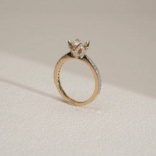 Floral Crown Solitaire Diamond Ring at an angle in 14KT Yellow Gold with pavé diamond band and round solitaire in petal crown setting.