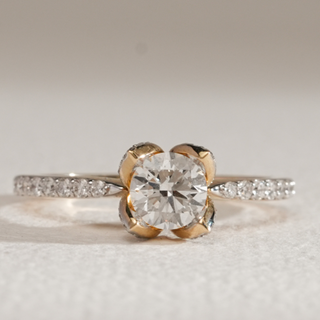 Close-up of Floral Crown Solitaire Diamond Ring in 14KT Yellow Gold with pavé band and round diamond in floral crown setting.