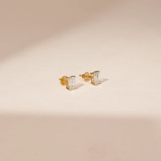 Side view of 14KT Yellow Gold diamond earrings featuring rectangular-cut diamonds in four-prong stud settings.
