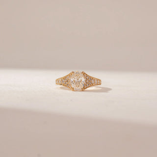 Front view of a 14KT Yellow Gold diamond ring featuring an oval centre diamond, pavé-set shoulders and intricate diamond detailing across the wide band.
