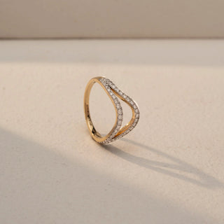 Angled view of a curved diamond wedding band in White Gold, featuring pavé-set lab-grown diamonds along a graceful V-shaped silhouette, displayed against a beige backdrop.