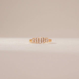 Front view of a diamond ring in 14KT Yellow Gold, featuring alternating baguette and round diamonds in a cluster setting against a beige backdrop.