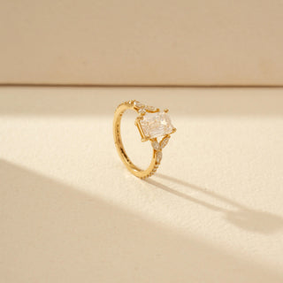 Angled view of Emerald-Cut Diamond Ring in 14KT Yellow Gold, featuring an emerald-cut centre diamond and marquise side diamonds.