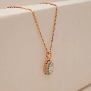 Side view of Classic Pear Halo Diamond Pendant in 18KT Rose Gold, featuring a pear-cut centre diamond encircled by a sparkling halo, suspended from a delicate rose gold chain.