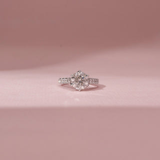 Front view of a 14KT White Gold diamond ring with a round centre diamond, six-prong setting and diamond-set shoulders.