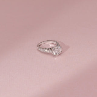 Side view of a 14KT White Gold diamond ring with a round centre diamond, six-prong setting and diamond-set shoulders.