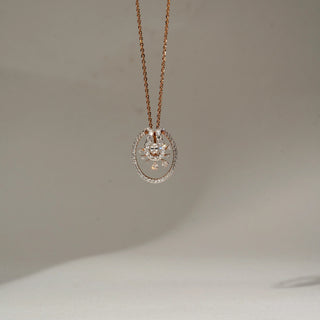 Front view of a rose gold oval pendant necklace featuring a pavé-set diamond frame and a delicate floral-inspired diamond motif, suspended from a fine chain against a neutral backdrop.