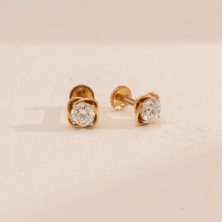 Top-down view of Reia’s 14 KT Yellow Gold Twisted Gold Motif Diamond Studs. It highlights the round-cut central diamonds and architectural twisted gold frames against a clean, cream backdrop.