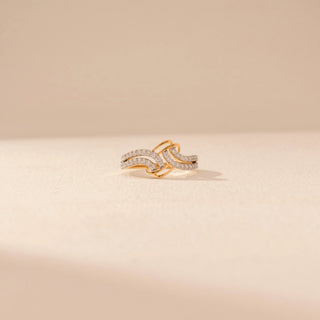 Front view of a 14KT yellow gold ring featuring round-cut diamonds in an interlocking wave design, set against a beige background.
