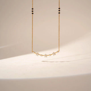 Front view of a 14KT Yellow Gold diamond mangalsutra featuring a curved bar with round-shaped diamond clusters and delicate chain detailing.