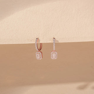 Angled view of Emerald-Cut Diamond Drop Earrings in 14KT Rose Gold, featuring rectangular emerald-cut diamonds with pavé halos.