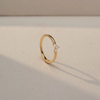 Angled view of a Trio Diamond Cluster Ring in 14KT Yellow Gold, featuring three round lab-grown diamonds in a vertical cluster. Shot against a beige backdrop, casting a soft shadow with elegant sparkle.