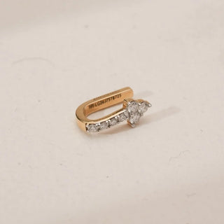 Side view of yellow gold diamond nosepin featuring a clover-shaped cluster of round lab-grown diamonds with a short pavé-set diamond bar, displayed on a neutral studio surface.