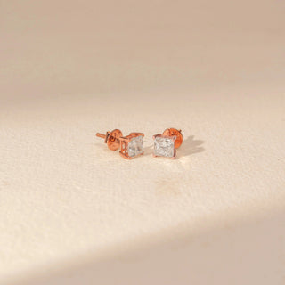 Angled view of Square Diamond Stud Earrings in 14KT Rose Gold, featuring matching square-cut diamonds in four-prong settings.