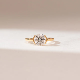 Front view of 14KT yellow gold ring featuring a round brilliant-cut centre diamond in a sleek bezel-style setting on a polished minimalist band.
