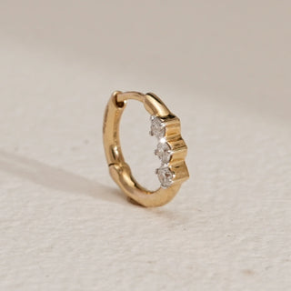 Petite three-stone diamond nose ring in 14KT Yellow Gold, shown upright on a neutral surface, featuring EF-VVS round diamonds in a minimal, elegant push-and-pull design.