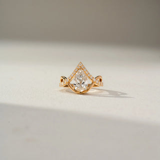 Front view of a pear-cut diamond ring in yellow gold, framed by a pavé diamond chevron design that creates a crown-inspired silhouette with elegant sparkle and symmetry.