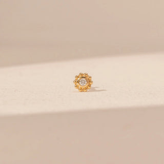 Front view of a floral diamond nosepin in 14KT yellow gold, featuring a round lab-grown diamond surrounded by a beaded halo.