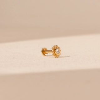 Side view of a floral diamond nosepin in 14KT yellow gold, featuring a round lab-grown diamond and beaded halo.