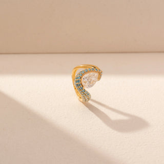 Angled view of Pear-Cut Diamond Ring in 14KT Yellow Gold, featuring a pear-shaped centre diamond with blue gemstone accents.