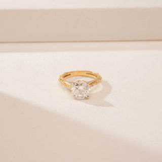 Front view of a 14KT Yellow Gold diamond ring, featuring a round centre diamond and diamond-set inner band.